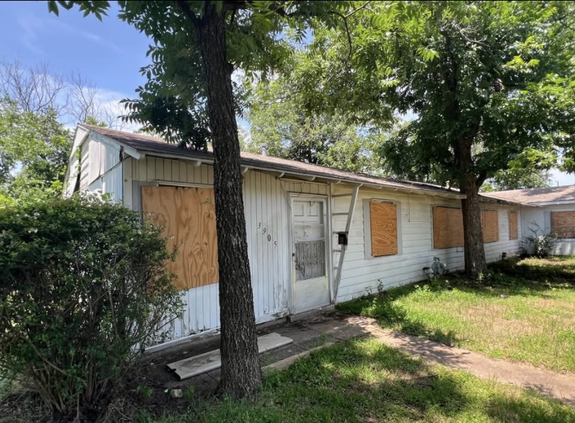 Boarded-up Texas house with overgrown yard